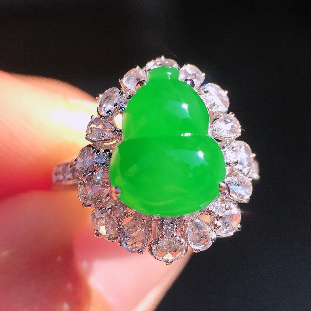 阳绿葫芦戒指，色泽均匀艳丽，玉质细腻，荧光感超
强，饱满圆润，尽显优雅气质，18k
金豪华镶嵌