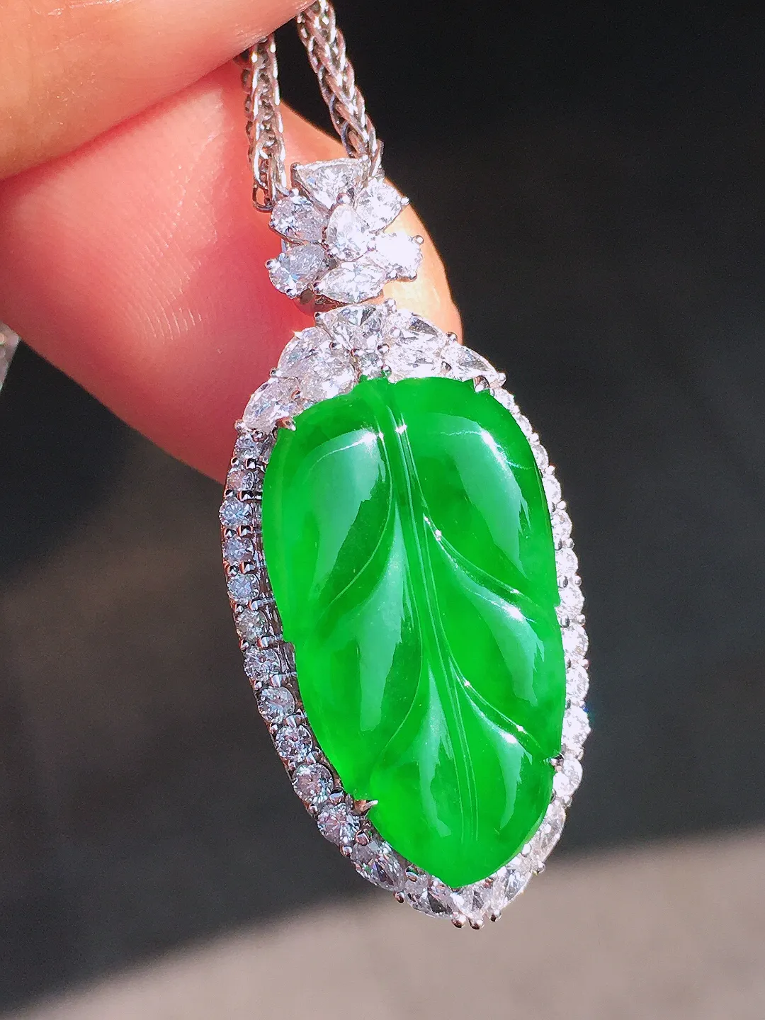 阳绿玉叶吊坠，色泽均匀艳丽，玉质细腻，荧光感超
强，饱满圆润，尽显优雅气质，18k
金豪华镶嵌