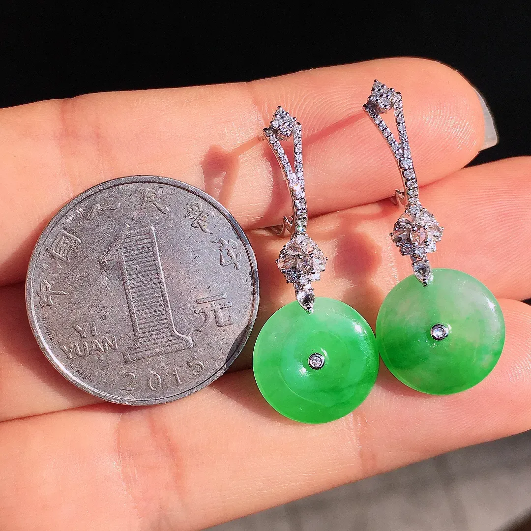 阳绿平安扣耳坠，色泽艳丽，玉质细腻，荧光感超
强，饱满圆润，尽显优雅气质，18k
金豪华镶嵌