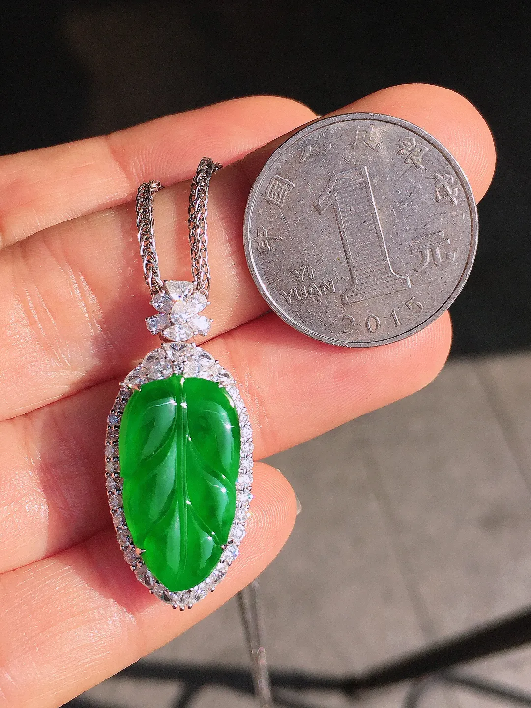 阳绿玉叶吊坠，色泽均匀艳丽，玉质细腻，荧光感超
强，饱满圆润，尽显优雅气质，18k
金豪华镶嵌
