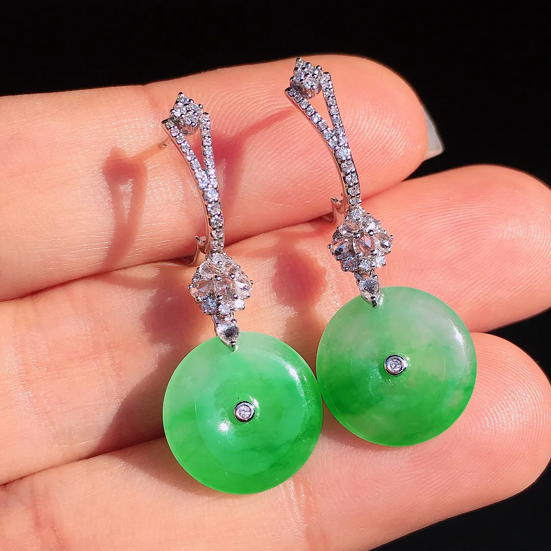 阳绿平安扣耳坠，色泽艳丽，玉质细腻，荧光感超
强，饱满圆润，尽显优雅气质，18k
金豪华镶嵌