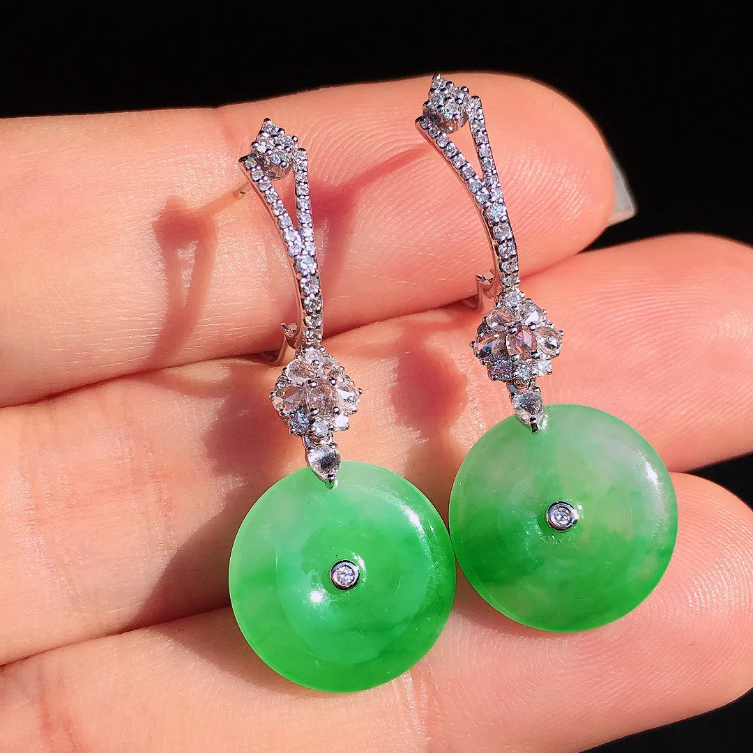 阳绿平安扣耳坠，色泽艳丽，玉质细腻，荧光感超
强，饱满圆润，尽显优雅气质，18k
金豪华镶嵌