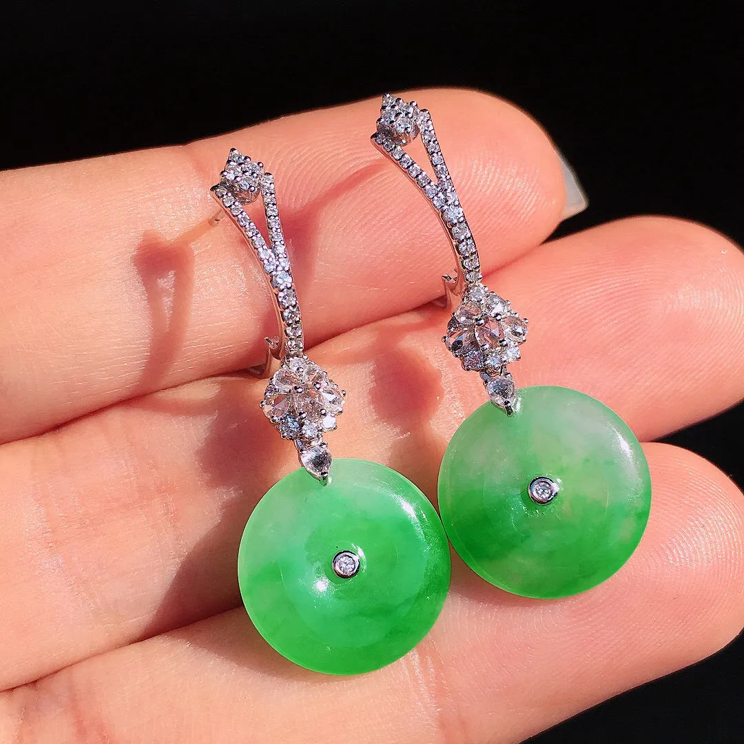 阳绿平安扣耳坠，色泽艳丽，玉质细腻，荧光感超
强，饱满圆润，尽显优雅气质，18k
金豪华镶嵌