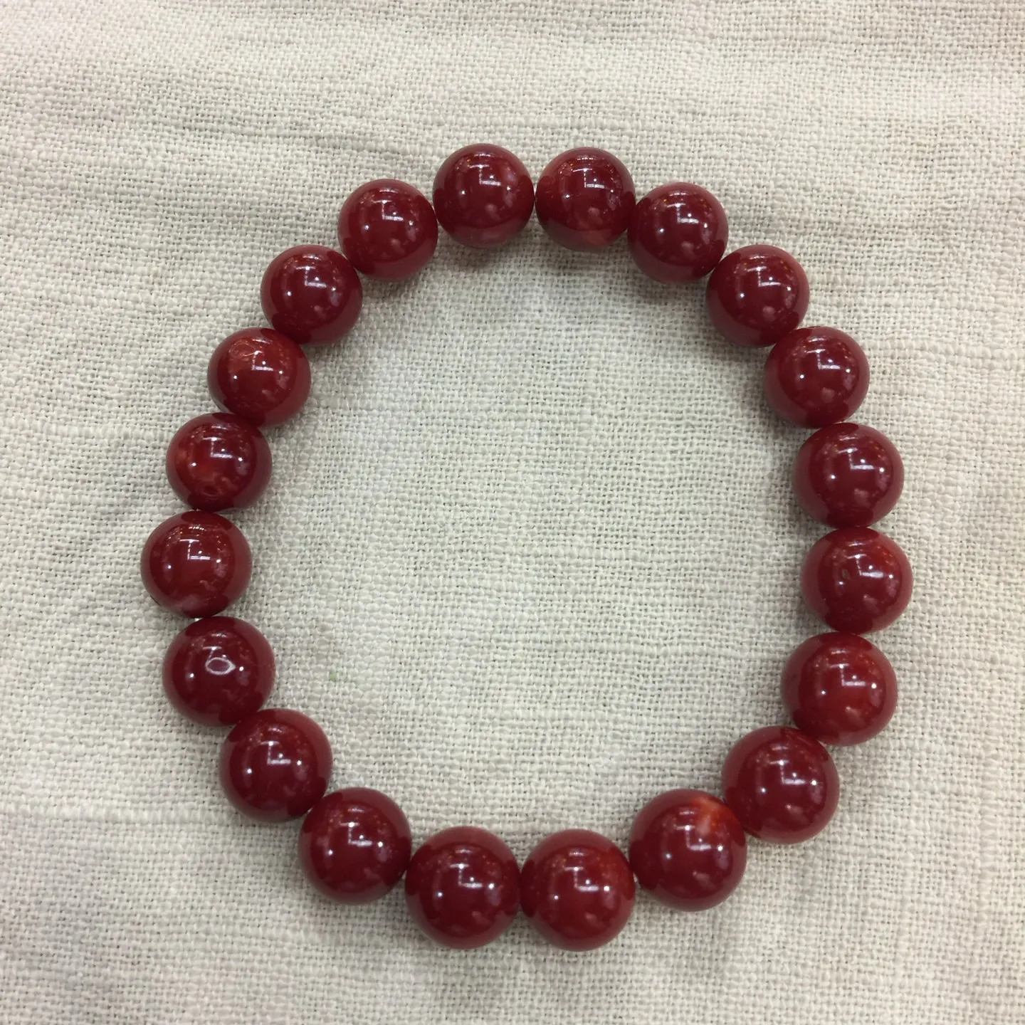 【天然日本阿卡牛血红珊瑚小10mm圆珠弹力单手串】难得高瓷度，日本产地，阿卡材料，整条少虫眼少白芯的阿卡圆珠。整条赤血牛血红颜色，珠子直径9.84-9.16mm，每颗珠子均为天然的珊瑚，珊瑚自古就为佛教珍宝，深海千年有机宝石！收藏价值高、可传承重量为23.25克！追求品质者的福音！实物漂亮！