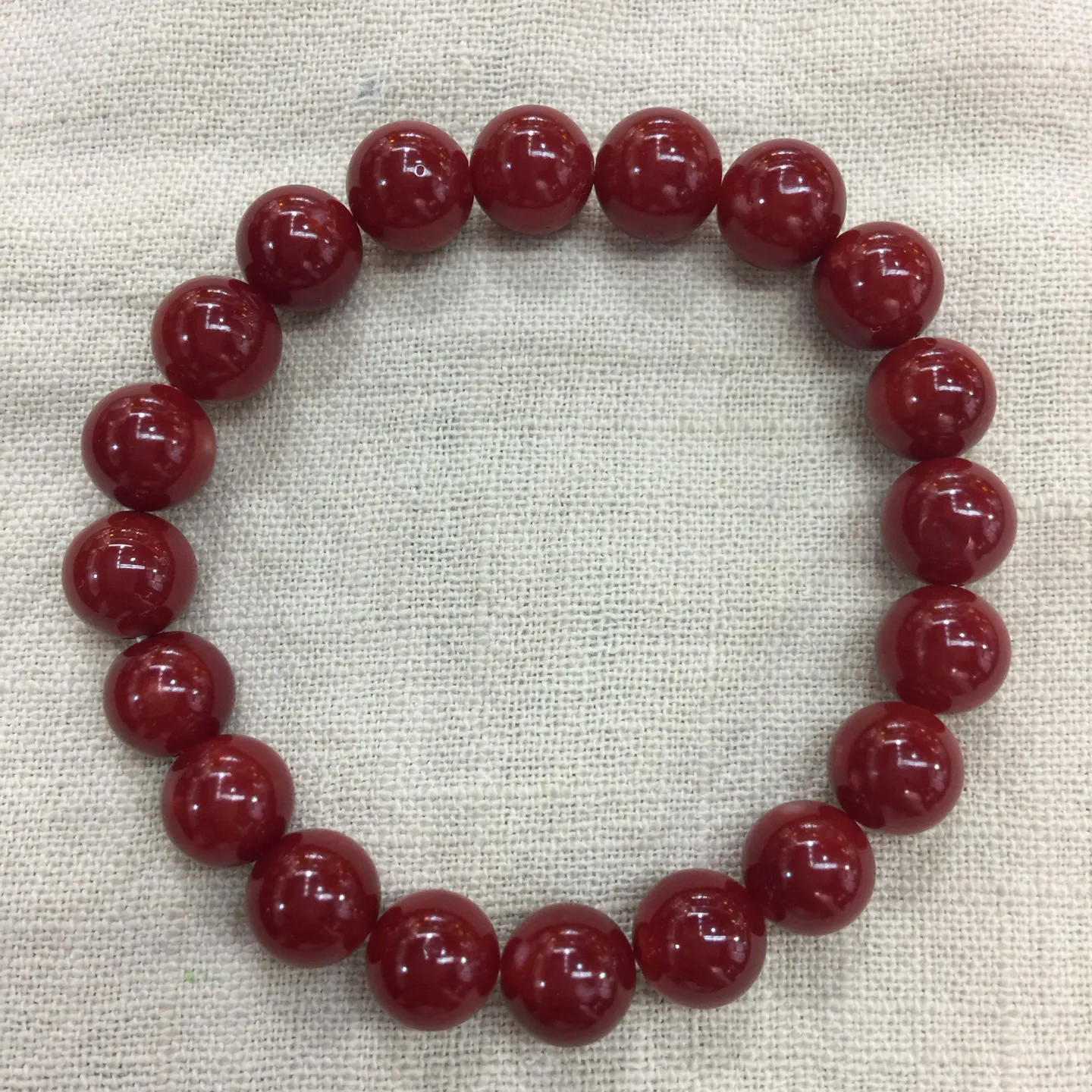 【天然日本阿卡牛血红珊瑚小10mm圆珠弹力单手串】难得高瓷度，日本产地，阿卡材料，整条少虫眼少白芯的阿卡圆珠。整条赤血牛血红颜色，珠子直径9.84-9.16mm，每颗珠子均为天然的珊瑚，珊瑚自古就为佛教珍宝，深海千年有机宝石！收藏价值高、可传承重量为23.25克！追求品质者的福音！实物漂亮！