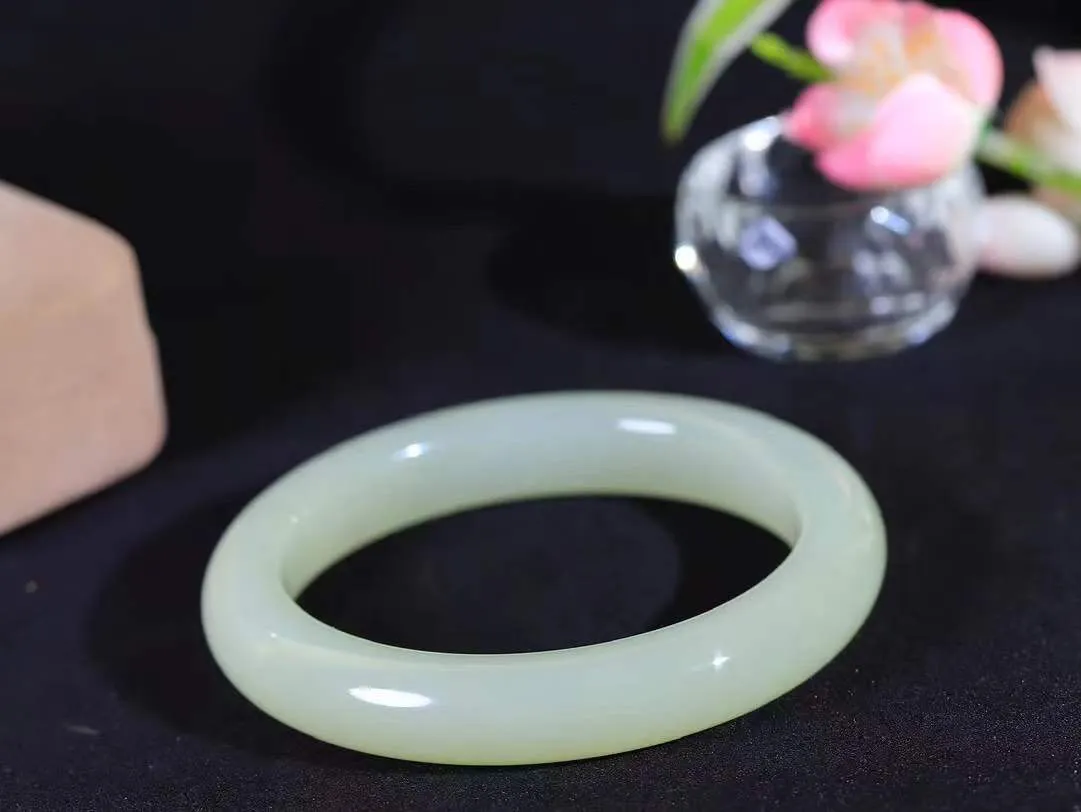 （一见倾心.手镯）

精品和田玉晴水手镯，玉质温润细腻 油性十足 手感舒适，高华雅逸，线条流畅，简约大气，美自天成，素雅高贵。佩戴于腕间，婉约之美，举手投足间透出那低调奢华。重63.3克  尺寸59.5-12-9.7mm  561252500A