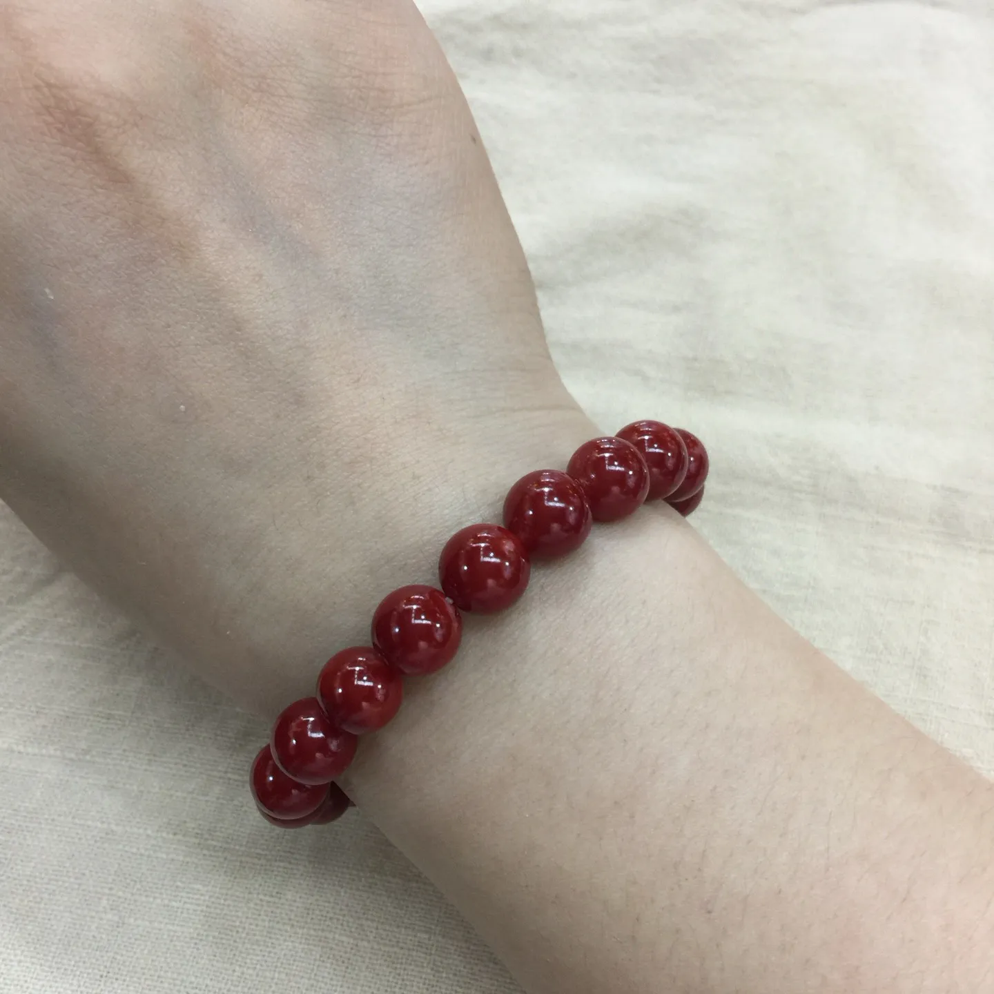 【天然日本阿卡牛血红珊瑚小10mm圆珠弹力单手串】难得高瓷度，日本产地，阿卡材料，整条少虫眼少白芯的阿卡圆珠。整条赤血牛血红颜色，珠子直径9.84-9.16mm，每颗珠子均为天然的珊瑚，珊瑚自古就为佛教珍宝，深海千年有机宝石！收藏价值高、可传承重量为23.25克！追求品质者的福音！实物漂亮！