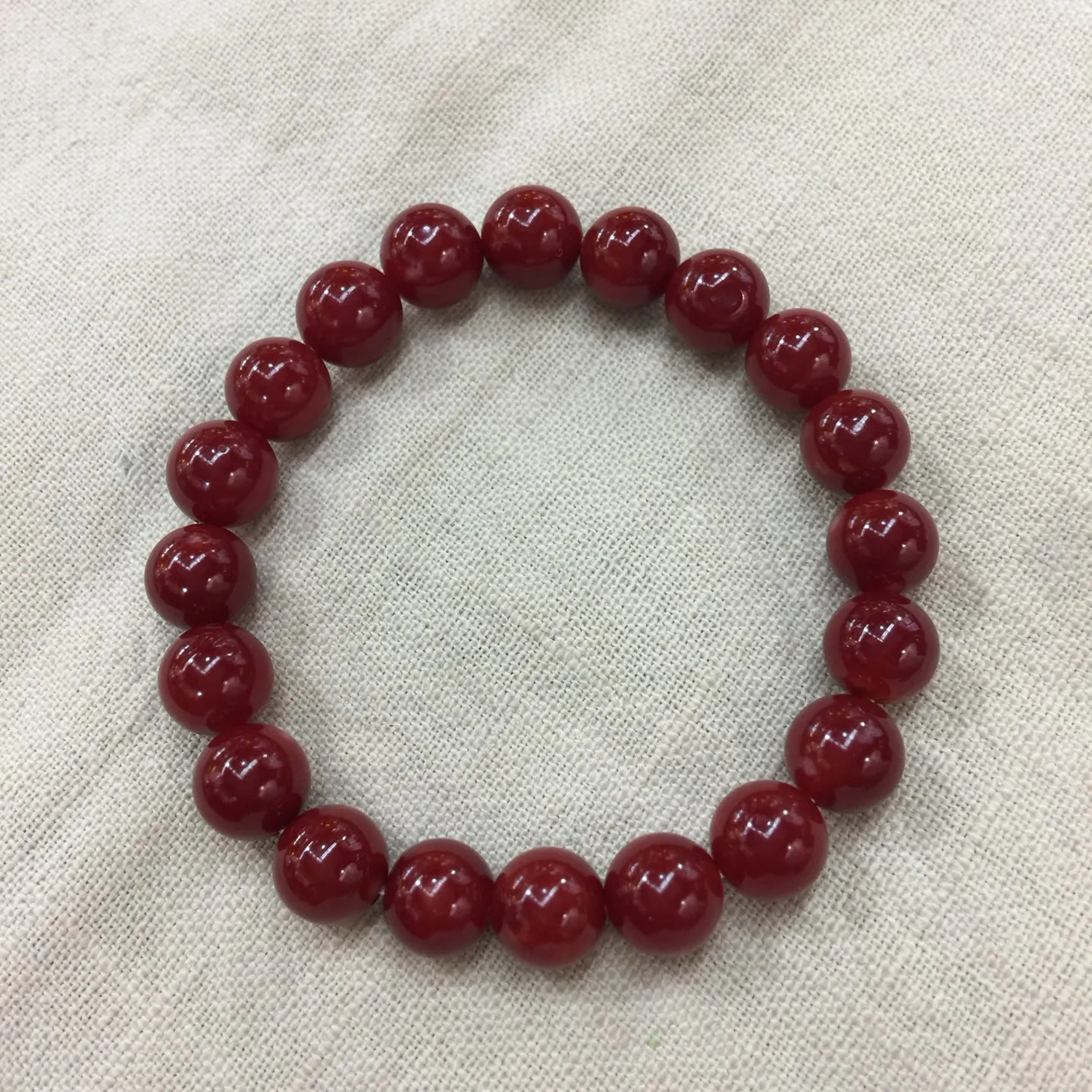 【天然日本阿卡牛血红珊瑚小10mm圆珠弹力单手串】难得高瓷度，日本产地，阿卡材料，整条少虫眼少白芯的阿卡圆珠。整条赤血牛血红颜色，珠子直径9.84-9.16mm，每颗珠子均为天然的珊瑚，珊瑚自古就为佛教珍宝，深海千年有机宝石！收藏价值高、可传承重量为23.25克！追求品质者的福音！实物漂亮！