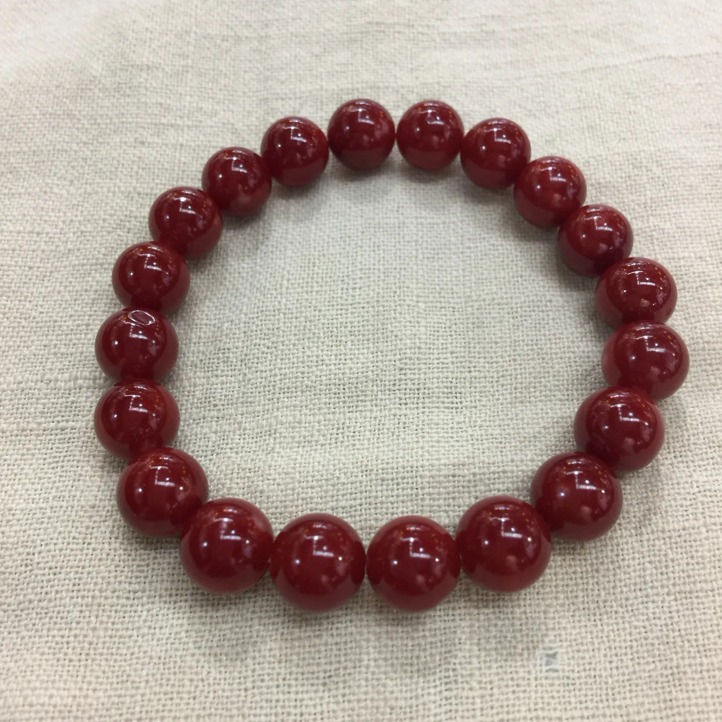 【天然日本阿卡牛血红珊瑚小10mm圆珠弹力单手串】难得高瓷度，日本产地，阿卡材料，整条少虫眼少白芯的阿卡圆珠。整条赤血牛血红颜色，珠子直径9.84-9.16mm，每颗珠子均为天然的珊瑚，珊瑚自古就为佛教珍宝，深海千年有机宝石！收藏价值高、可传承重量为23.25克！追求品质者的福音！实物漂亮！