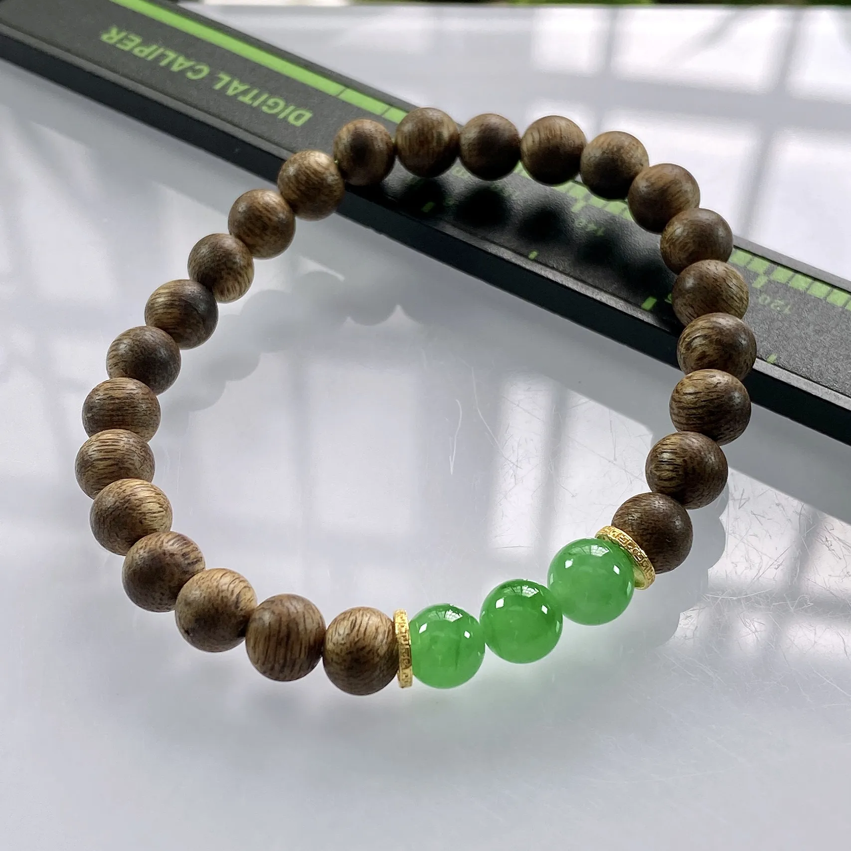 收藏级别，缅甸天然翡翠A货，卡7冰绿圆珠手串手链，尺寸：7mm/3颗，重量：3.75g，隔片为18k金，配饰为沉香木。