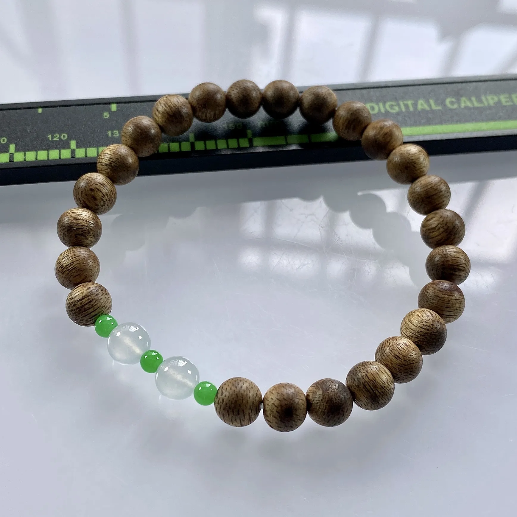 缅甸天然翡翠A货，卡6.2高冰种起光起胶双彩圆珠手串手链，尺寸：大珠6.2mm/2颗，小珠：3.3mm/3颗，重量：2.84g，配饰为沉香木。