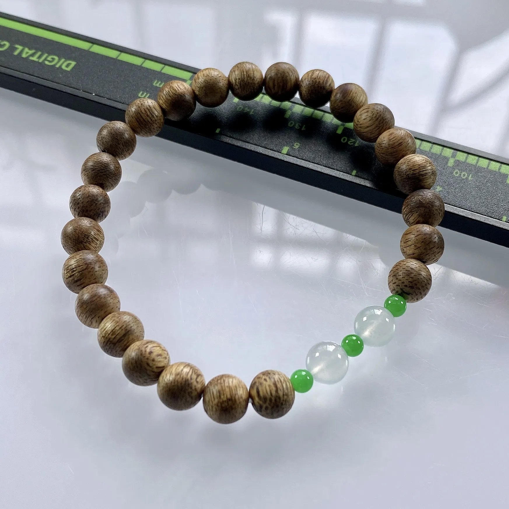 缅甸天然翡翠A货，卡6.2高冰种起光起胶双彩圆珠手串手链，尺寸：大珠6.2mm/2颗，小珠：3.3mm/3颗，重量：2.84g，配饰为沉香木。