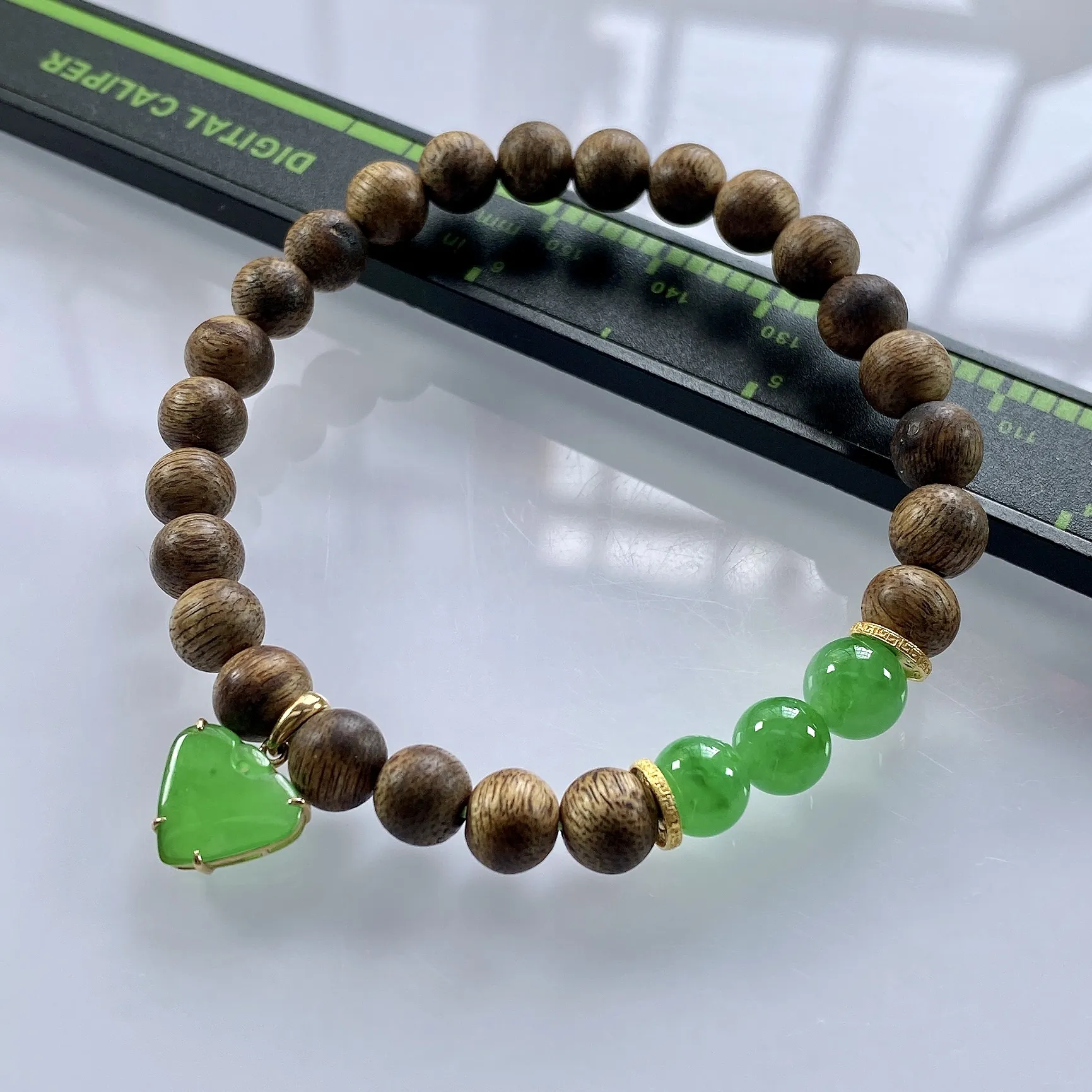 收藏级别，缅甸天然翡翠A货，卡7冰绿圆珠手串手链，尺寸：圆珠7mm/3颗，心形：11.2/10mm，重量：4.40g，桃心镶嵌及隔片为18k金，配饰为沉香木。