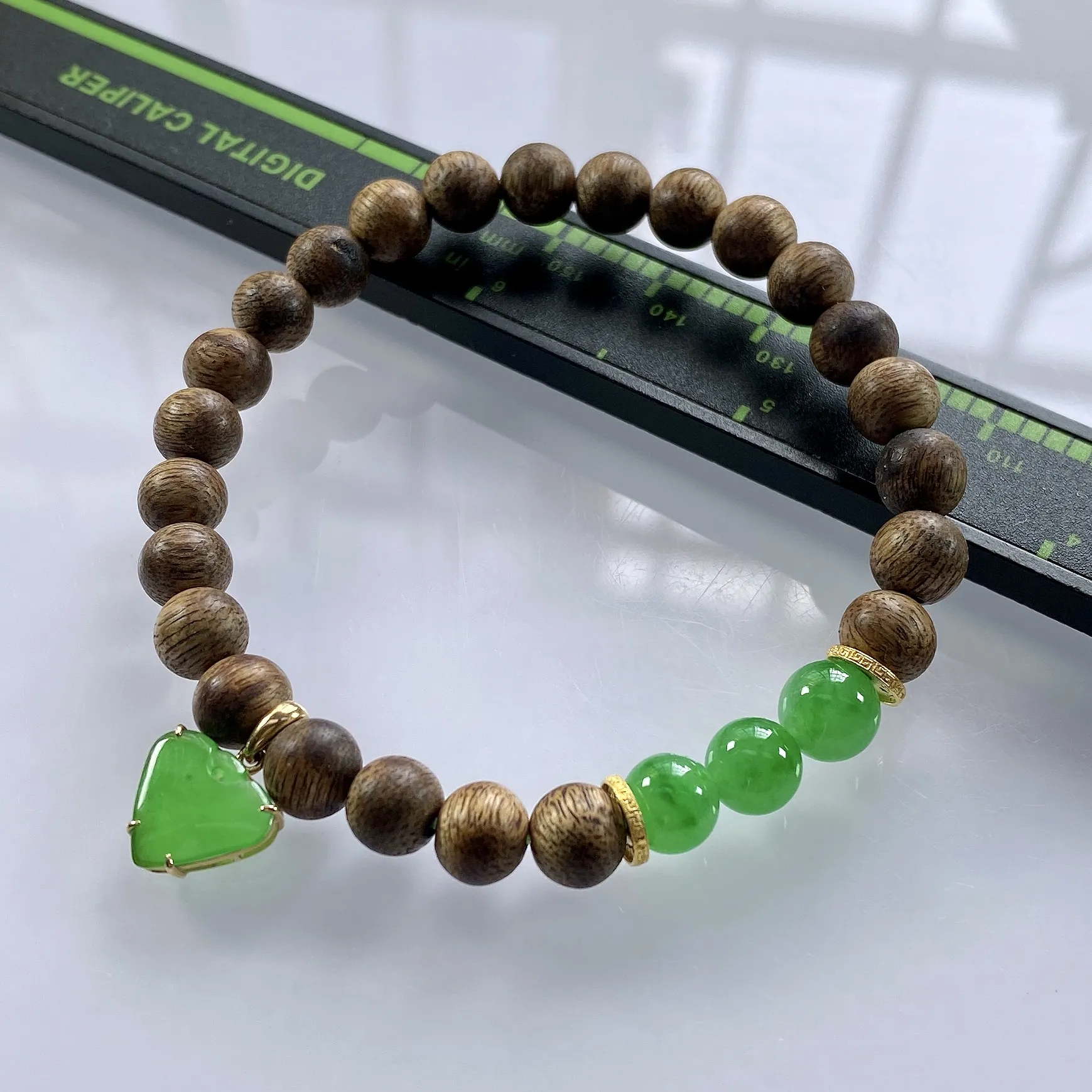 收藏级别，缅甸天然翡翠A货，卡7冰绿圆珠手串手链，尺寸：圆珠7mm/3颗，心形：11.2/10mm，重量：4.40g，桃心镶嵌及隔片为18k金，配饰为沉香木。