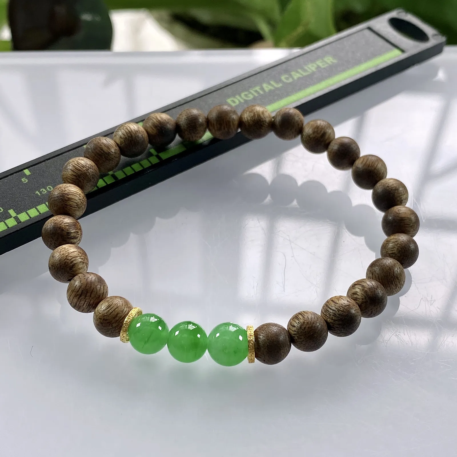 收藏级别，缅甸天然翡翠A货，卡7冰绿圆珠手串手链，尺寸：7mm/3颗，重量：3.75g，隔片为18k金，配饰为沉香木。
