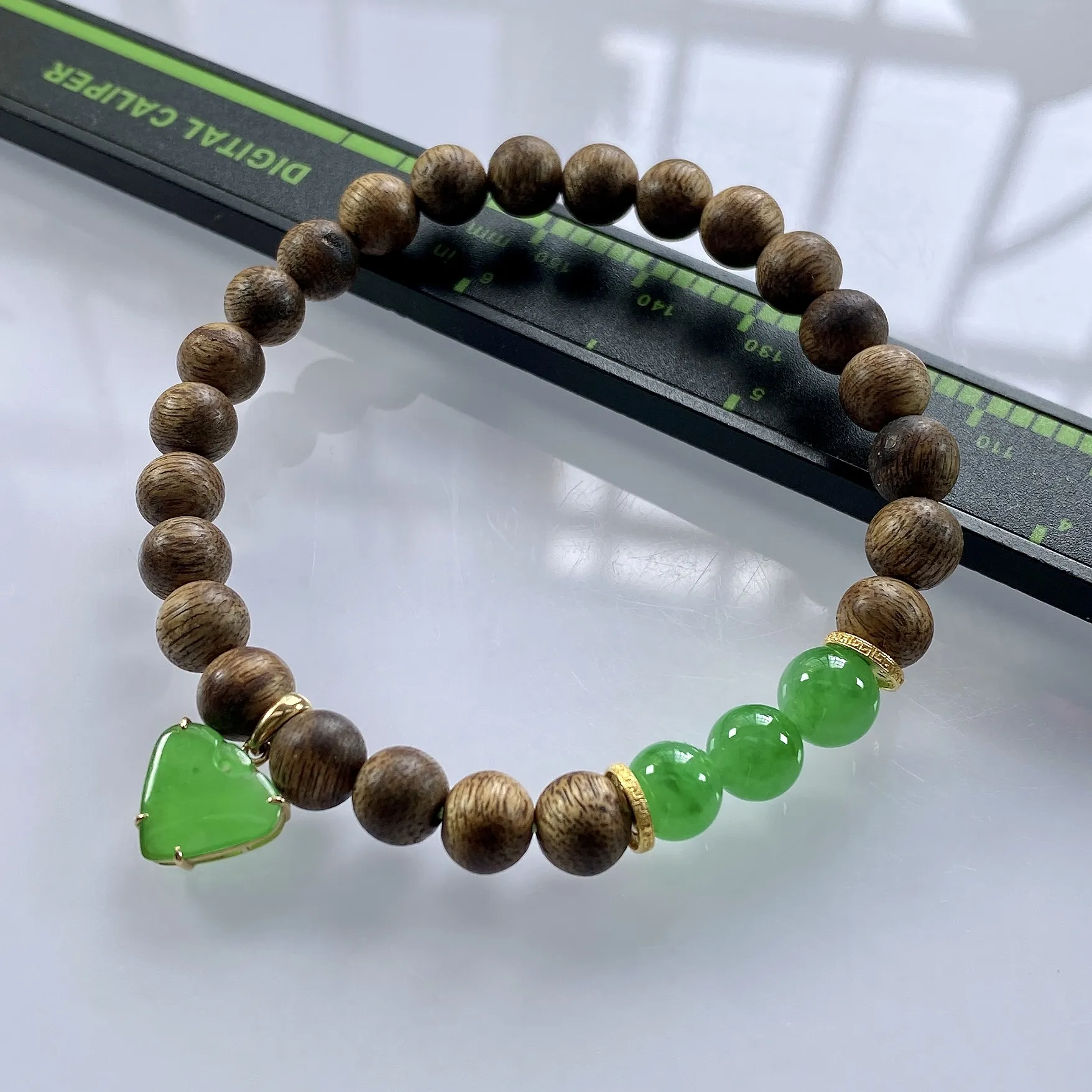 收藏级别，缅甸天然翡翠A货，卡7冰绿圆珠手串手链，尺寸：圆珠7mm/3颗，心形：11.2/10mm，重量：4.40g，桃心镶嵌及隔片为18k金，配饰为沉香木。