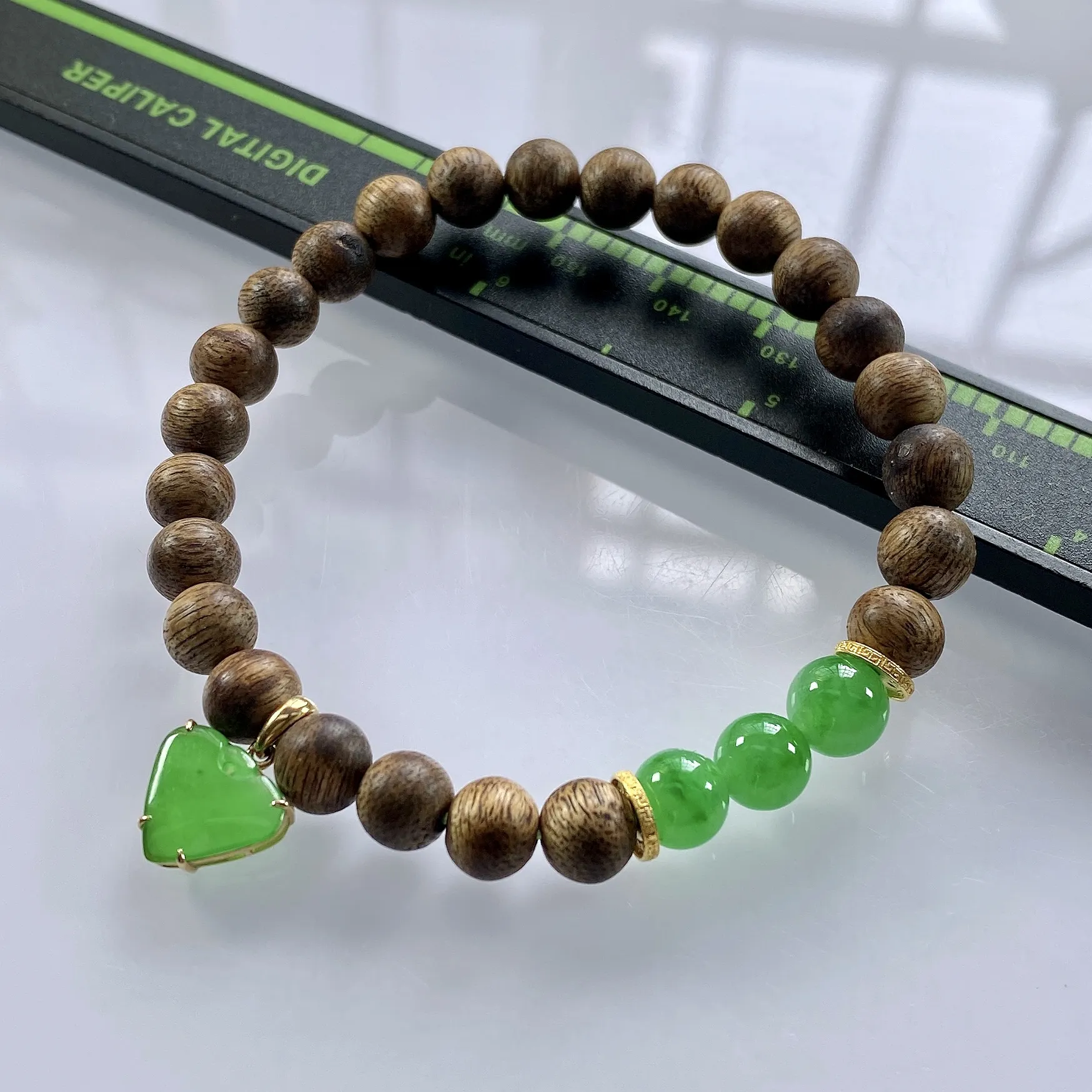 收藏级别，缅甸天然翡翠A货，卡7冰绿圆珠手串手链，尺寸：圆珠7mm/3颗，心形：11.2/10mm，重量：4.40g，桃心镶嵌及隔片为18k金，配饰为沉香木。