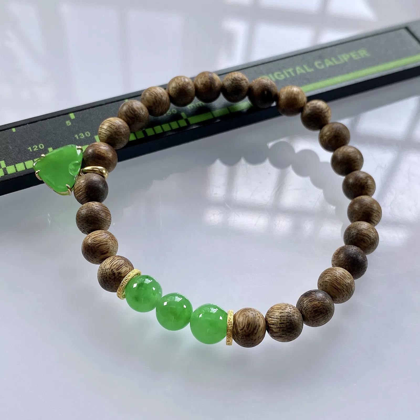 收藏级别，缅甸天然翡翠A货，卡7冰绿圆珠手串手链，尺寸：圆珠7mm/3颗，心形：11.2/10mm，重量：4.40g，桃心镶嵌及隔片为18k金，配饰为沉香木。