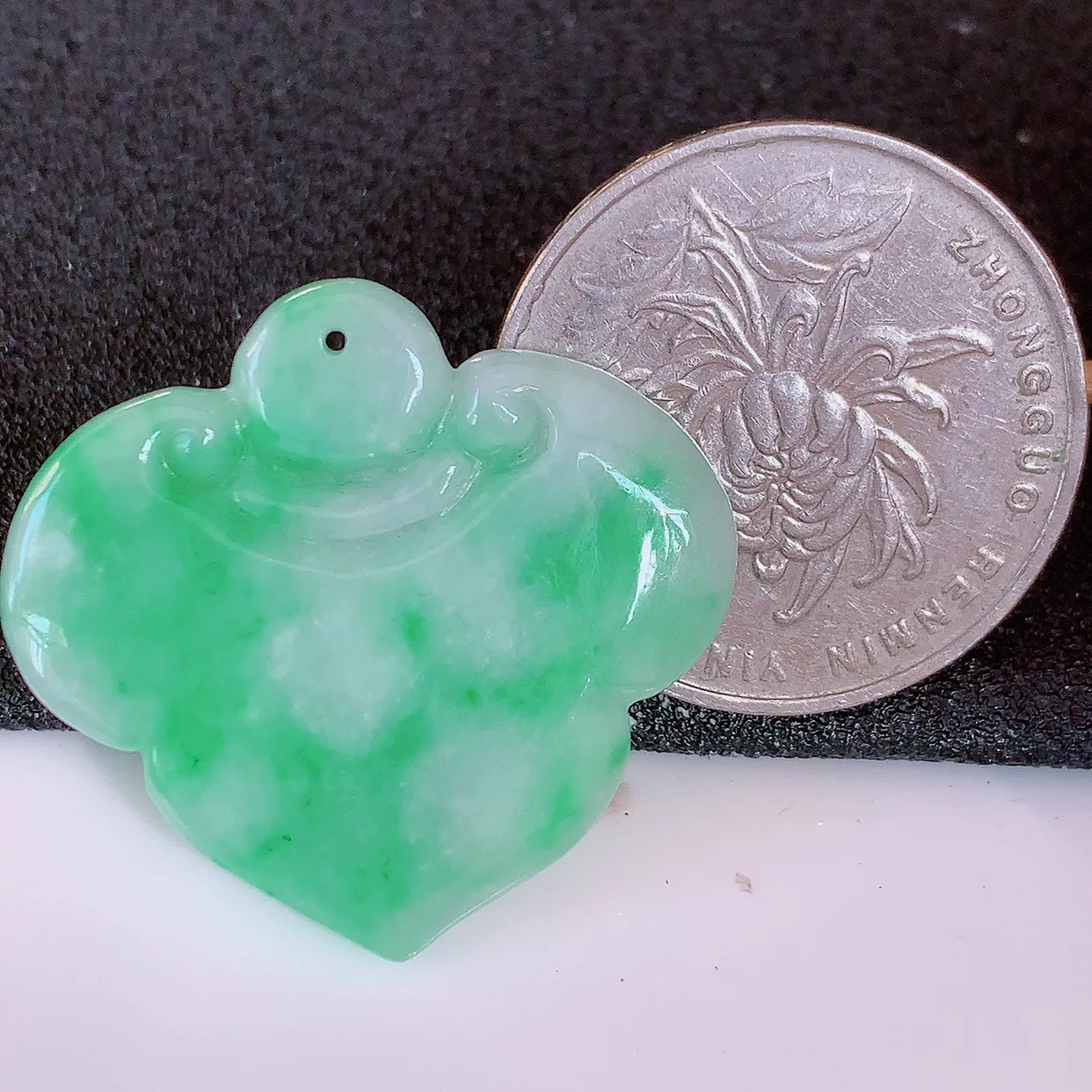 自然光实拍，冰润飘绿翡翠如意吊坠，翠色灵动，佩戴效果时尚出众，尽显气质，玉质细腻，美感十足。#57.28