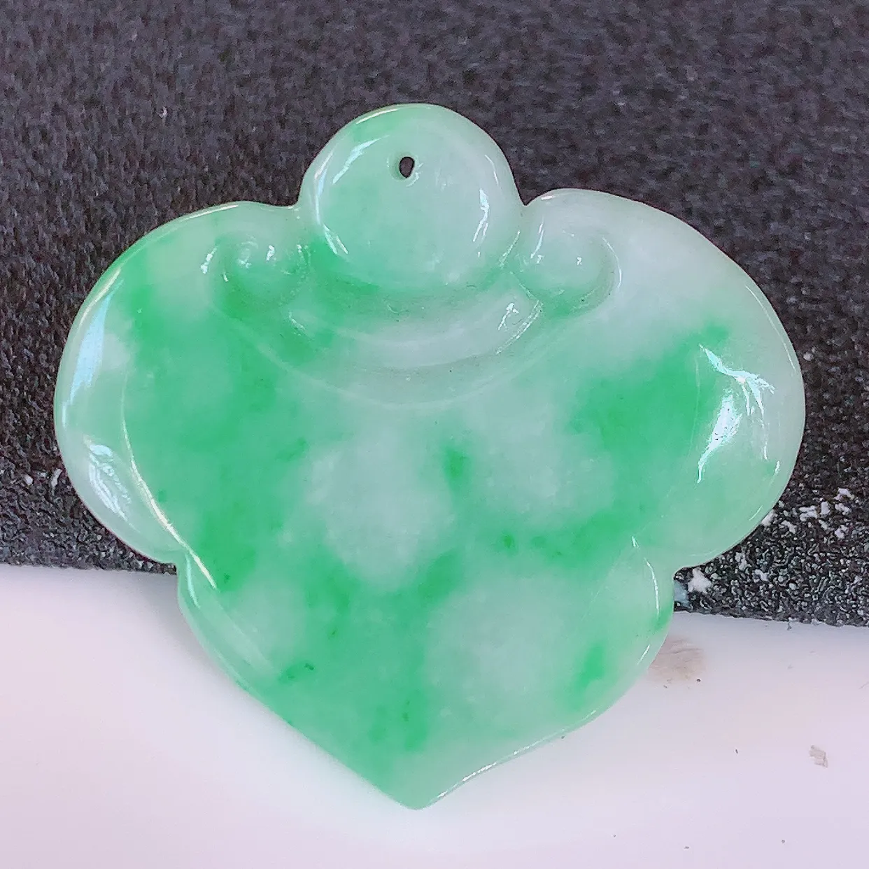 自然光实拍，冰润飘绿翡翠如意吊坠，翠色灵动，佩戴效果时尚出众，尽显气质，玉质细腻，美感十足。#57.28