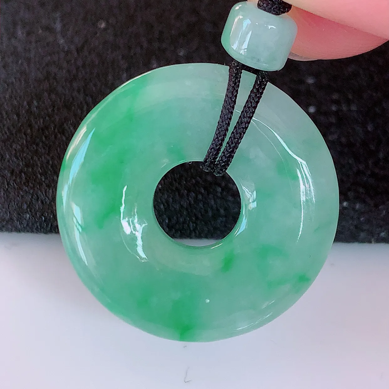 自然光实拍，冰润飘绿翡翠平安扣吊坠，翠色灵动，佩戴效果时尚出众，尽显气质，玉质细腻，美感十足。#57.28