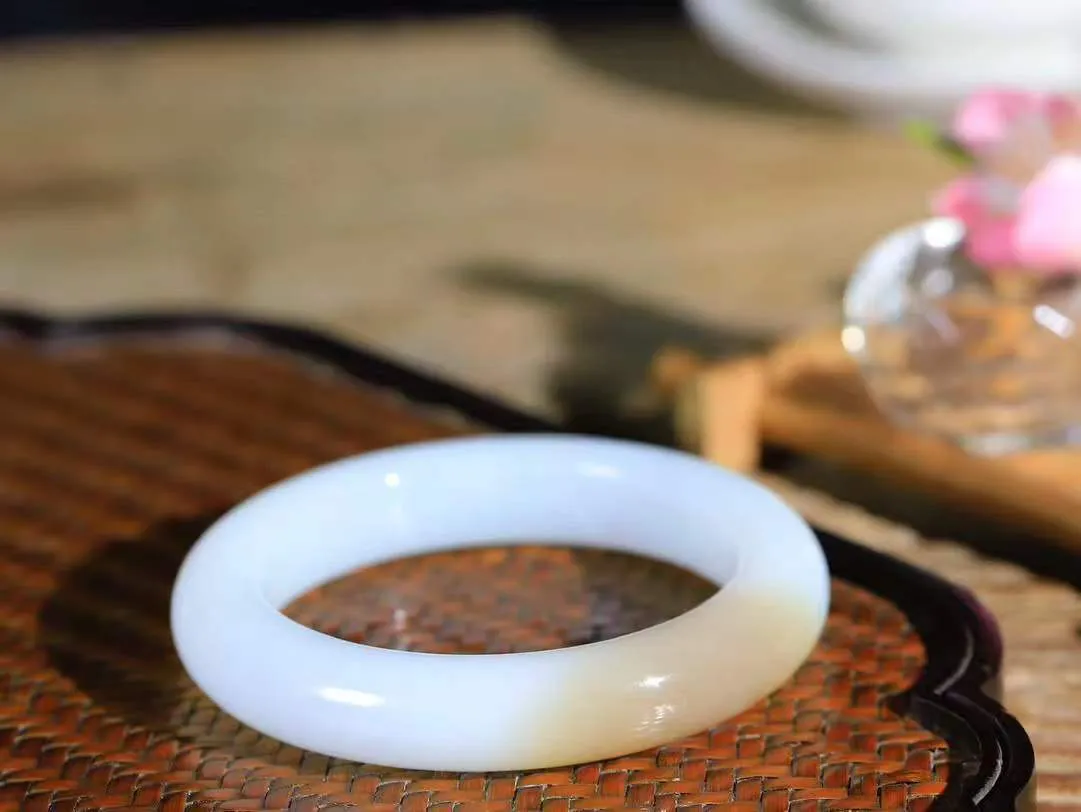 （一见倾心.手镯）

精品和田玉糖白玉手镯，玉质温润细腻 油性十足 手感舒适，高华雅逸，线条流畅，简约大气，美自天成，素雅高贵。佩戴于腕间，婉约之美，举手投足间透出那低调奢华。重65.5克  尺寸55-12.5-10.4mm  561253100A