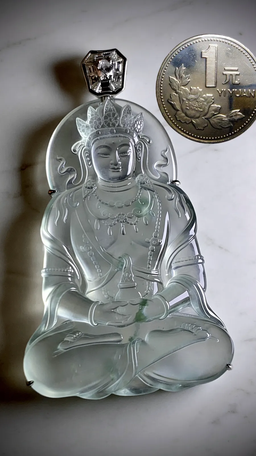 【慈悲无量】。
翡翠度母菩萨，莹润冰透，飘花藏禅意，
法相端庄，眉眼含慈，静坐似纳天地清宁。藏玉之灵秀，蕴之慈悲，福慧绵长。
山海玉雕艺术雕刻，
作品裸石61-42.2-5.2mm，整体71-42.2-7mm，
33.53g，18K金，南非钻，