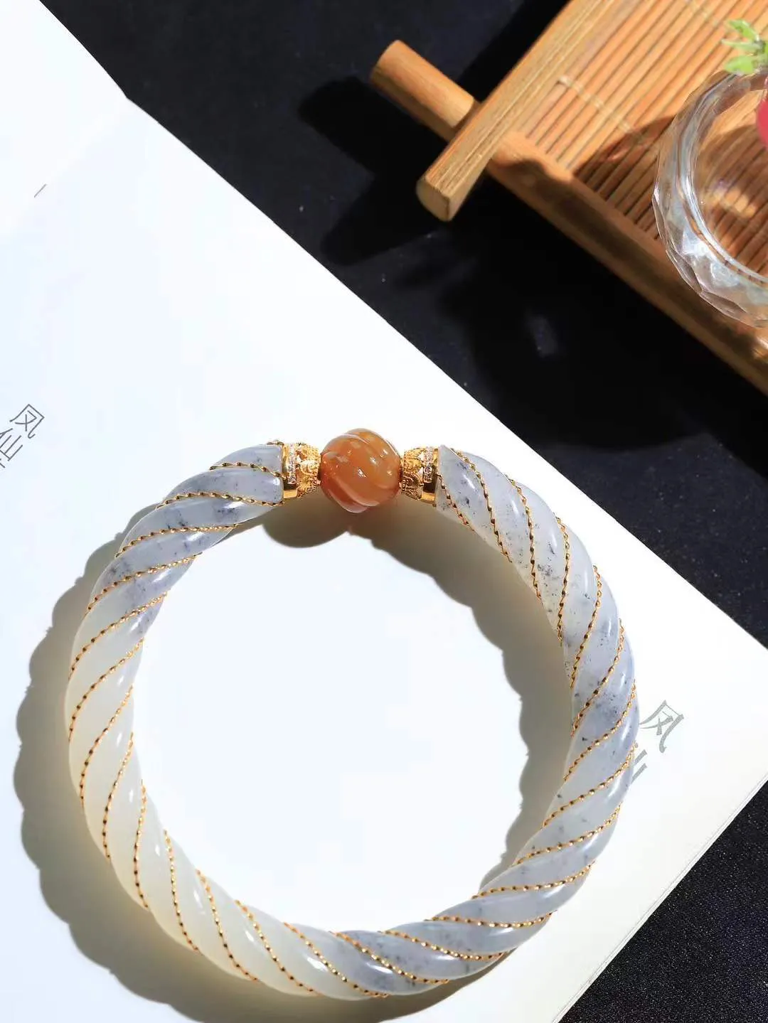 【麻花.手镯】

精品和田玉三色18k金镶嵌麻花手镯，玉质温润细腻，做工精湛，昆仑雪色凝作绕指柔，双股玉丝盘绕成圆满。纹如藤蔓相生，喻情缘坚韧交织；形似时空之环，藏天地生生不息。佩于腕间，是柔韧的智慧，亦是绵长的祝福——让每一次缠绕，都成为时光里解不开的缘分结。重37.6克   尺寸59.5-9.2-9.2mm  8910300L
