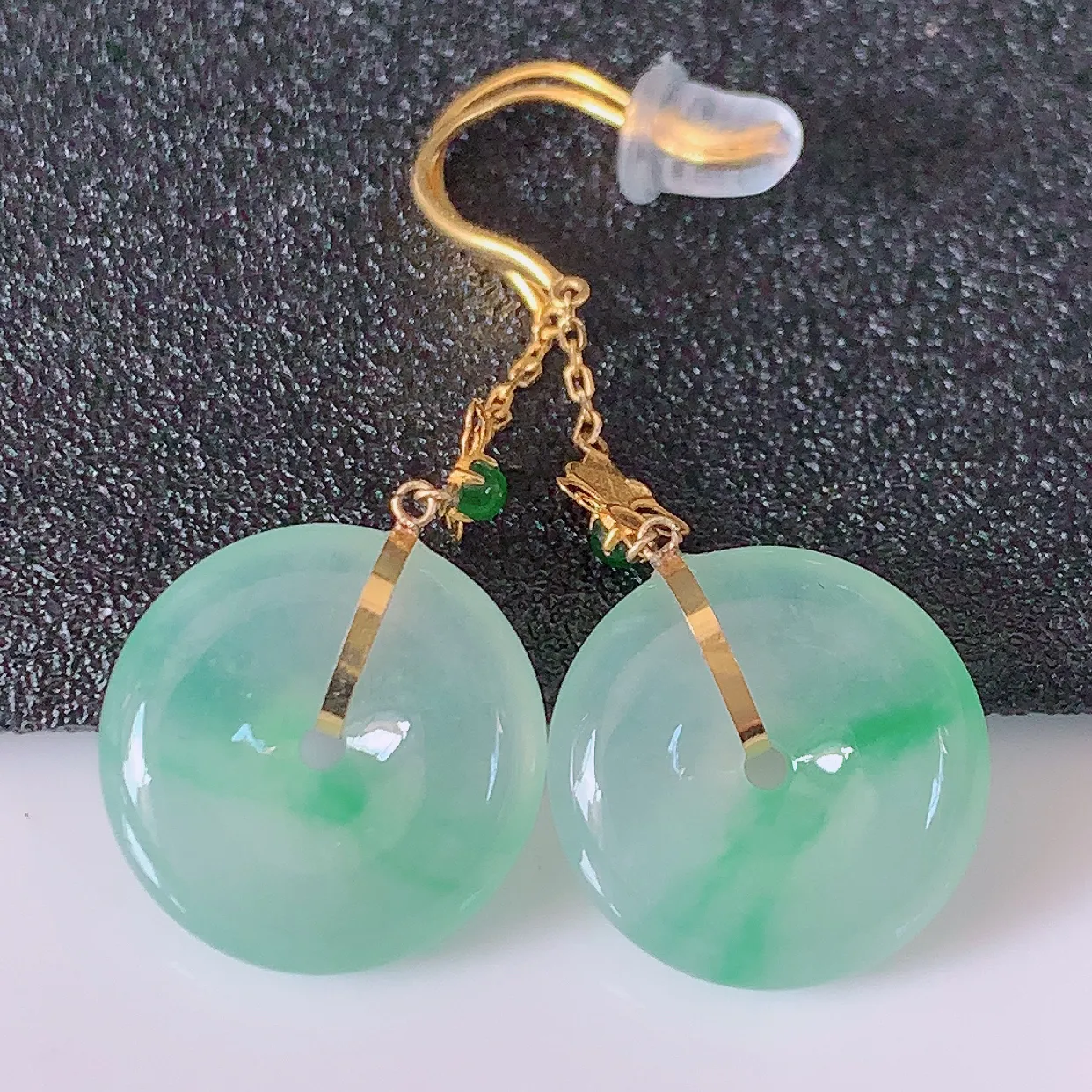 18k金镶嵌冰种飘绿翡翠平安扣耳坠，沁人心脾，耳坠佩戴效果大气出众，尽显气质。种水好，胶感足，颜相当