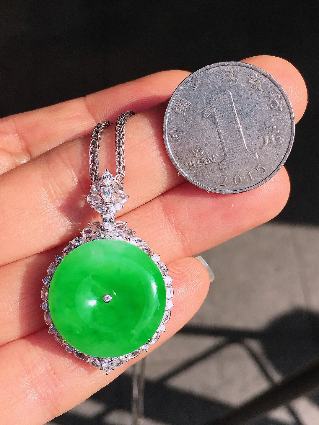 阳绿平安扣吊坠，色泽均匀艳丽，玉质细腻，荧光感超
强，饱满圆润，尽显优雅气质，18k
金豪华镶嵌