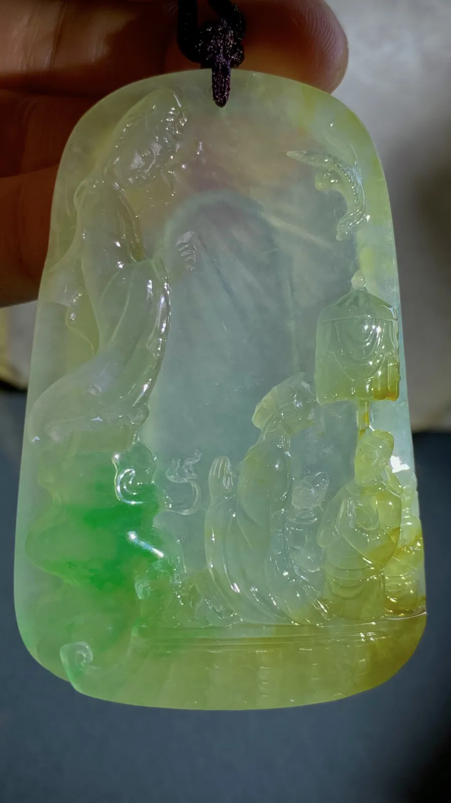 【许愿取真经】，老蒋玉雕艺术作品，
巧用冰种黄加绿翡翠的色彩与质地，雕刻出唐僧立志取经的场景，人物惟妙惟肖，把“坚定信念、不畏艰险、终成正果”的取经精神融入玉雕之中。
69-46-11.5mm，含绳65g