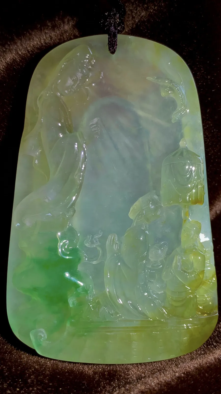 【许愿取真经】，老蒋玉雕艺术作品，
巧用冰种黄加绿翡翠的色彩与质地，雕刻出唐僧立志取经的场景，人物惟