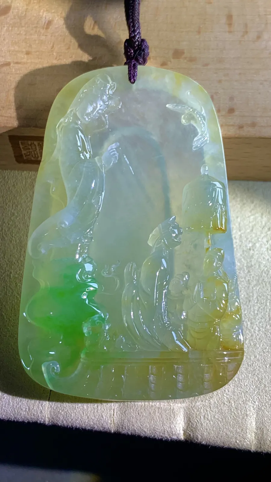 【许愿取真经】，老蒋玉雕艺术作品，
巧用冰种黄加绿翡翠的色彩与质地，雕刻出唐僧立志取经的场景，人物惟妙惟肖，把“坚定信念、不畏艰险、终成正果”的取经精神融入玉雕之中。
69-46-11.5mm，含绳65g