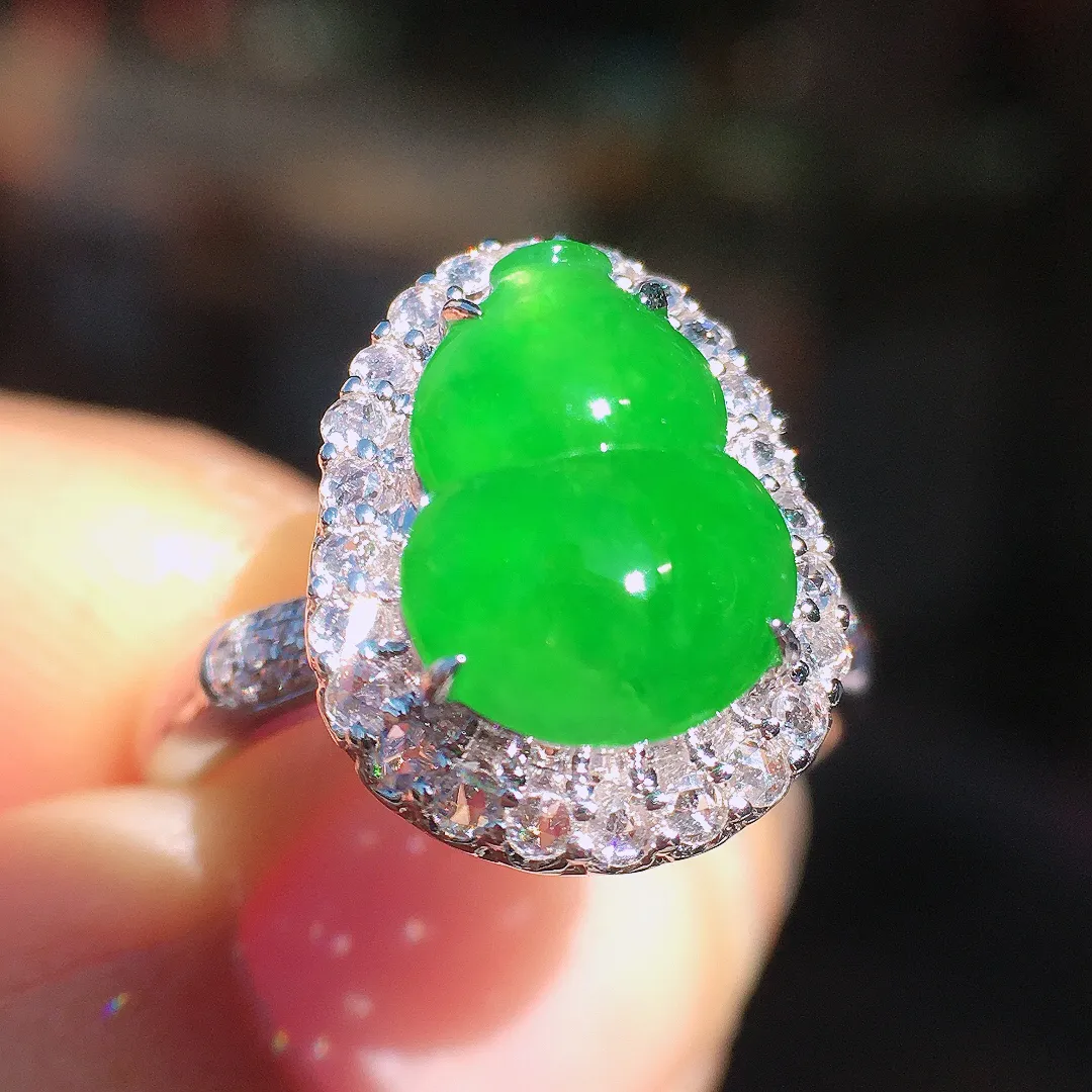 阳绿葫芦戒指，色泽均匀艳丽，玉质细腻，荧光感超
强，饱满圆润，尽显优雅气质，18k
金豪华镶嵌