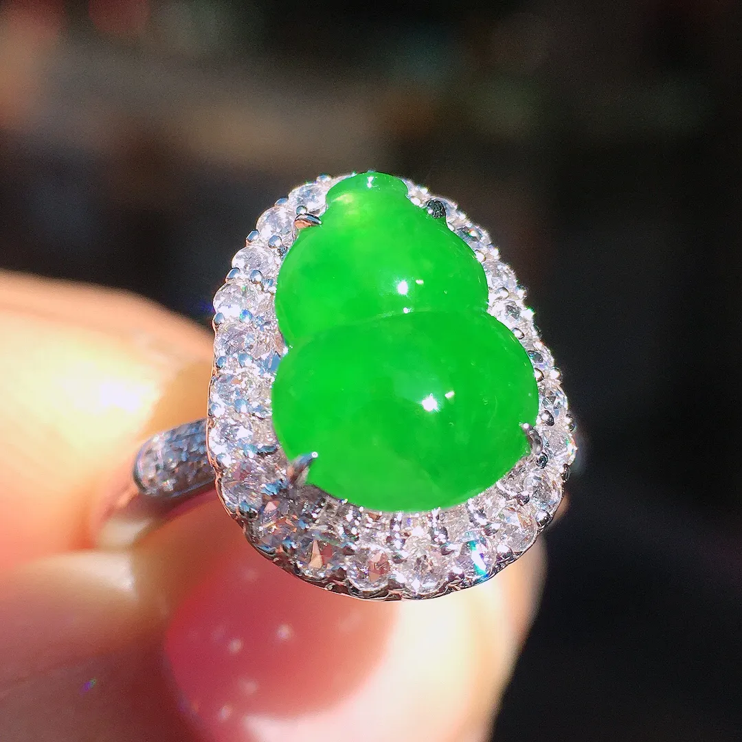 阳绿葫芦戒指，色泽均匀艳丽，玉质细腻，荧光感超
强，饱满圆润，尽显优雅气质，18k
金豪华镶嵌