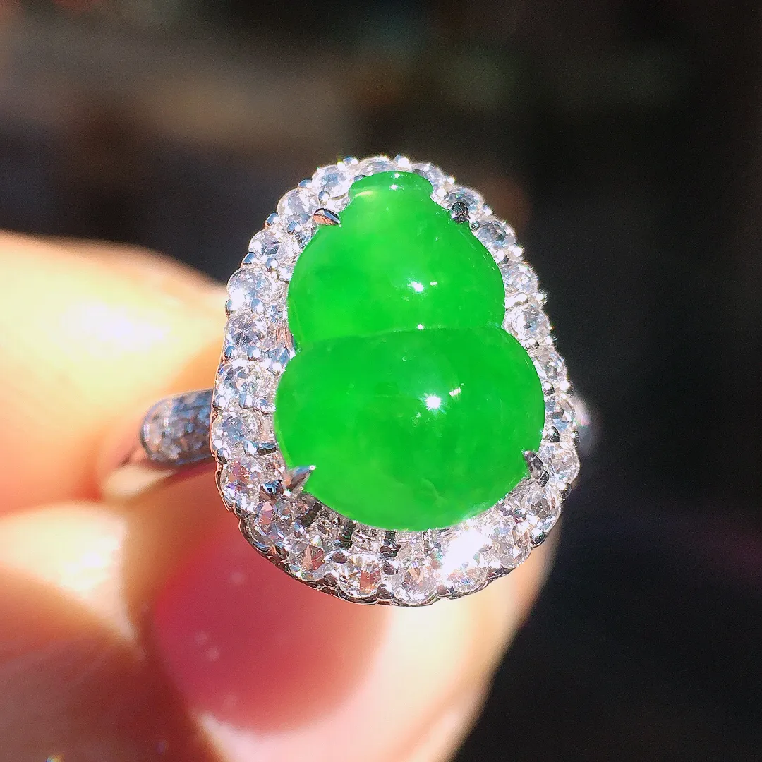 阳绿葫芦戒指，色泽均匀艳丽，玉质细腻，荧光感超
强，饱满圆润，尽显优雅气质，18k
金豪华镶嵌