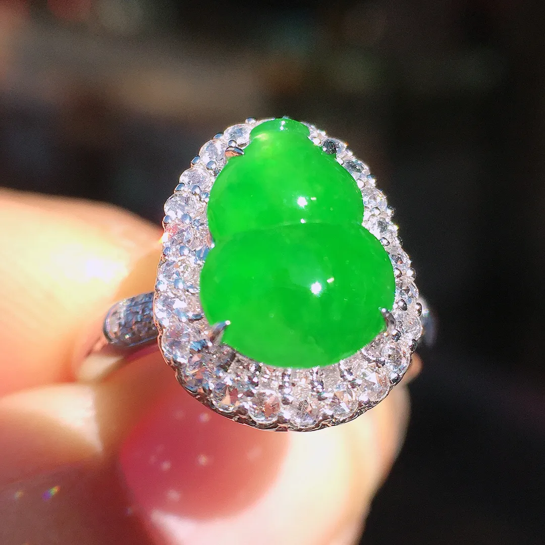 阳绿葫芦戒指，色泽均匀艳丽，玉质细腻，荧光感超
强，饱满圆润，尽显优雅气质，18k
金豪华镶嵌