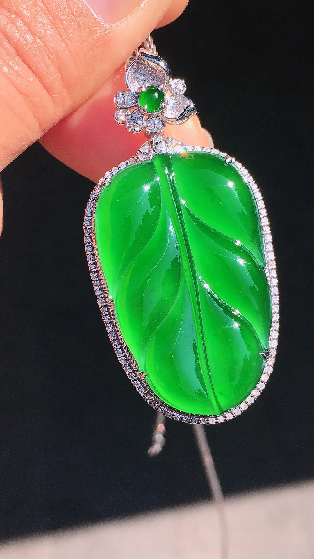 阳绿玉叶吊坠，色泽均匀艳丽，玉质细腻，荧光感超
强，饱满圆润，尽显优雅气质，18k
金豪华镶嵌