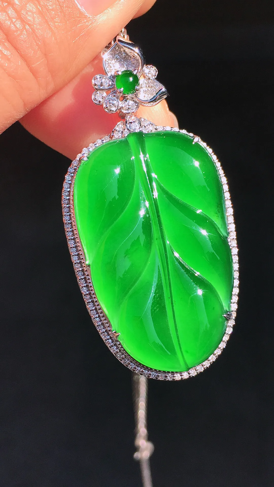 阳绿玉叶吊坠，色泽均匀艳丽，玉质细腻，荧光感超
强，饱满圆润，尽显优雅气质，18k
金豪华镶嵌