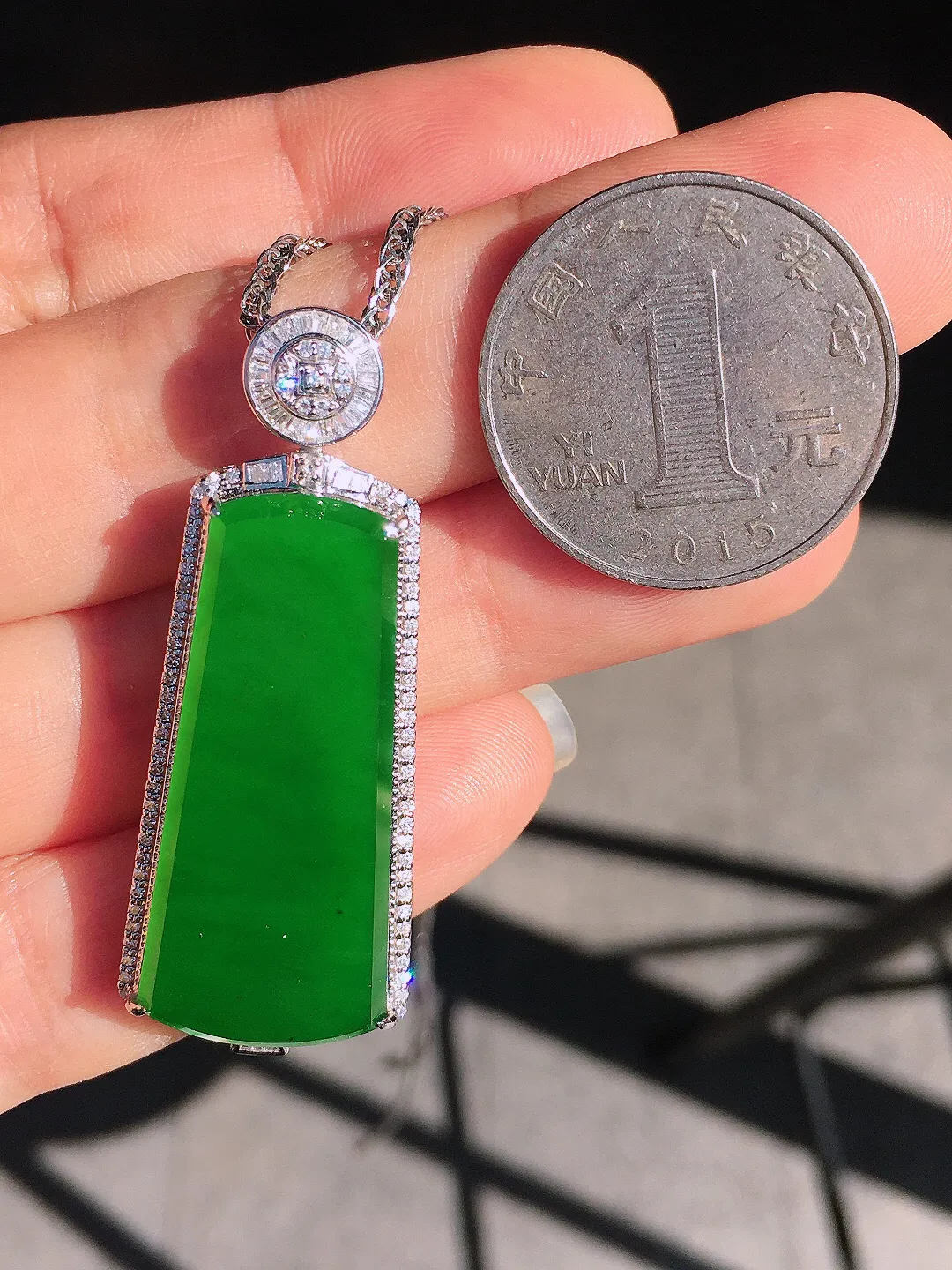 阳绿无事牌吊坠，色泽均匀艳丽，玉质细腻，荧光感超
强，饱满圆润，尽显优雅气质，18k
金豪华镶嵌