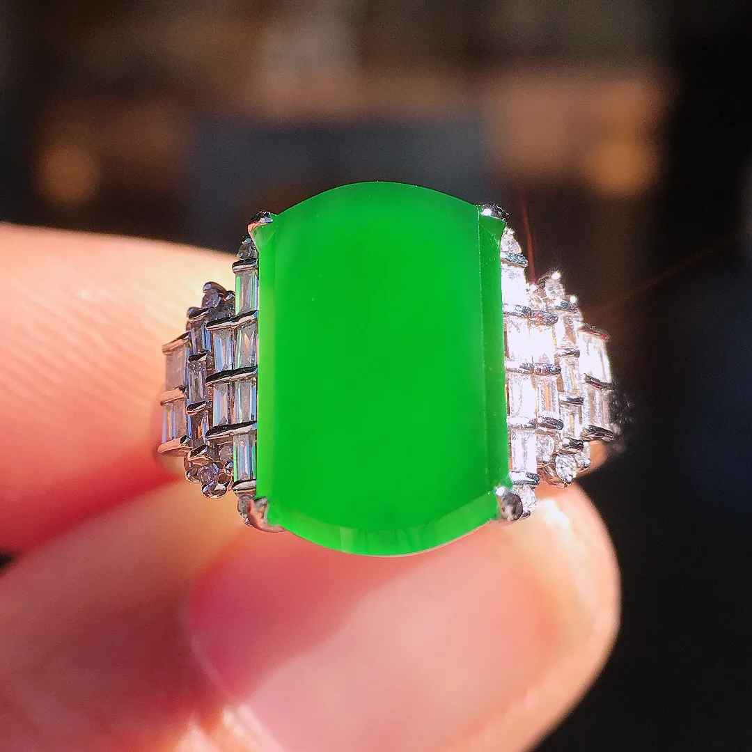 阳绿马鞍戒指，色泽均匀艳丽，玉质细腻，荧光感超
强，饱满圆润，尽显优雅气质，18k
金豪华镶嵌