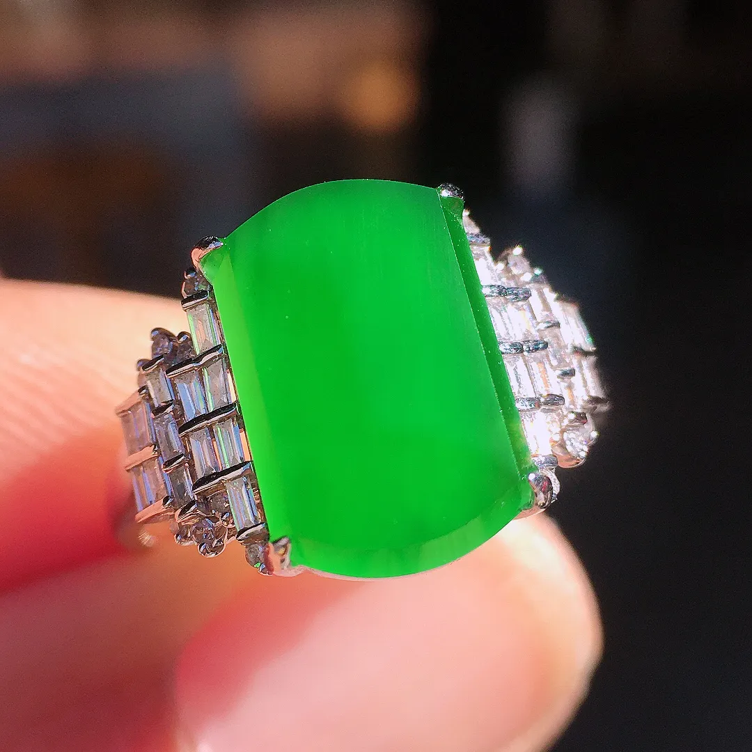 阳绿马鞍戒指，色泽均匀艳丽，玉质细腻，荧光感超
强，饱满圆润，尽显优雅气质，18k
金豪华镶嵌