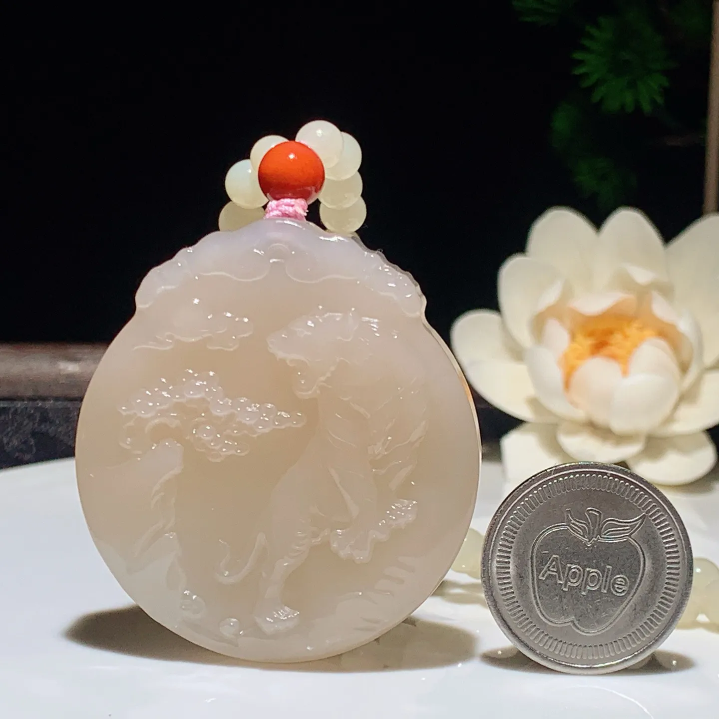 和田玉藕粉上山虎圆牌挂件。尺寸53/48/11重87克。无裂无杂无结构 玉质细腻油润。手推出油品相大气。250109