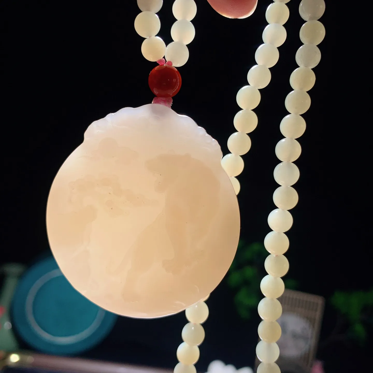 和田玉藕粉上山虎圆牌挂件。尺寸53/48/11重87克。无裂无杂无结构 玉质细腻油润。手推出油品相大气。250109