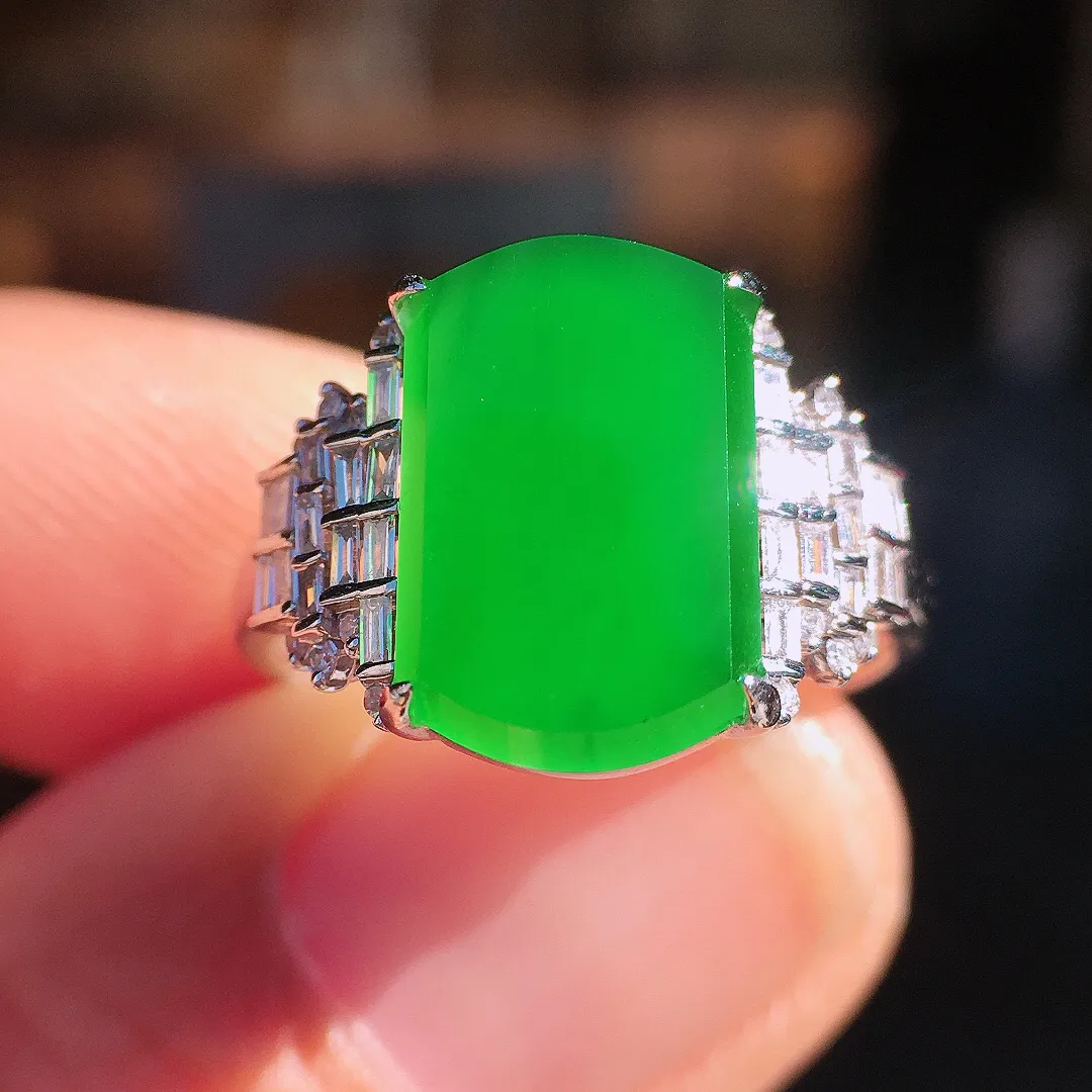 阳绿马鞍戒指，色泽均匀艳丽，玉质细腻，荧光感超
强，饱满圆润，尽显优雅气质，18k
金豪华镶嵌