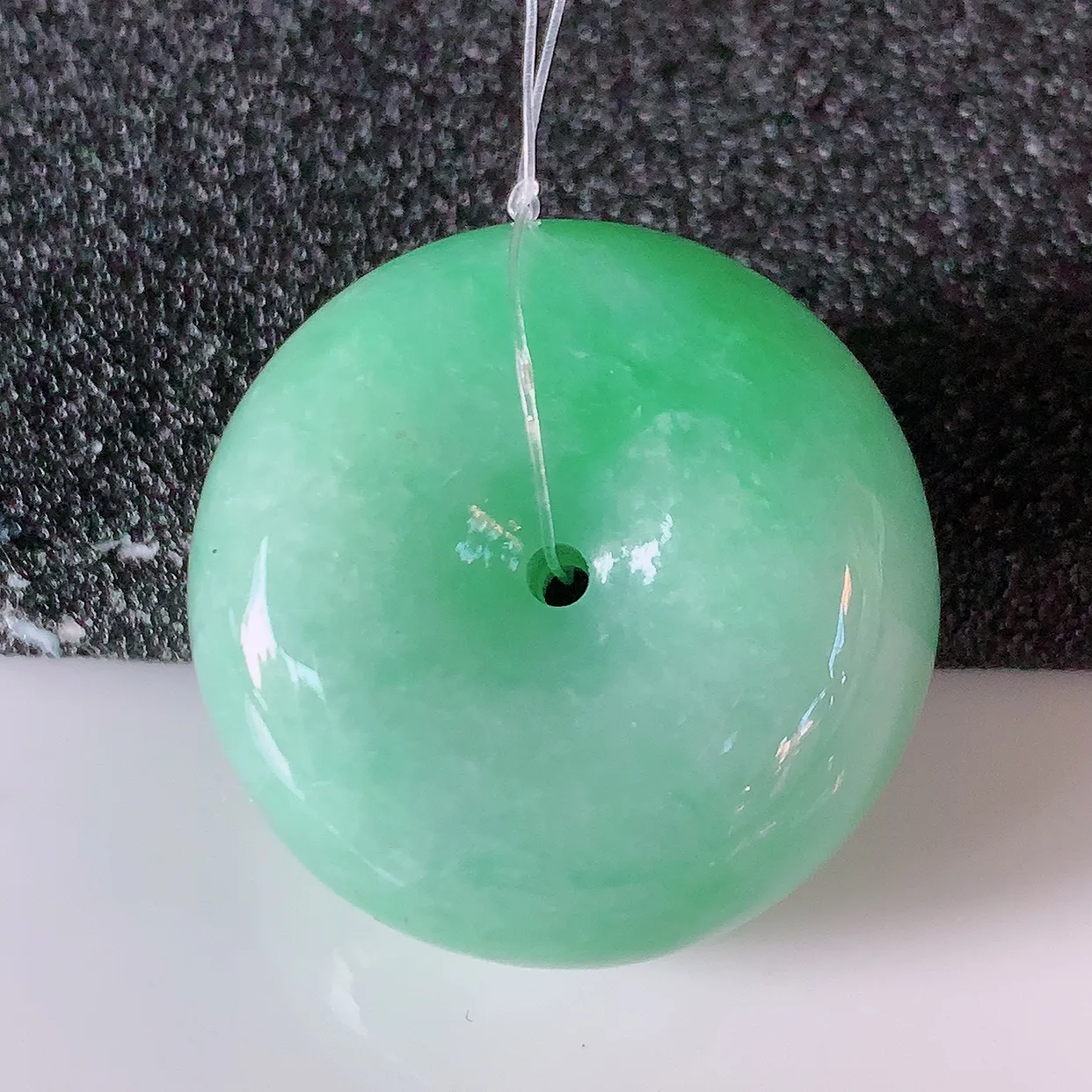 自然光实拍，冰润飘绿翡翠平安扣吊坠，形体饱满圆润，平安扣肥嘟嘟的，平平安安，种水很好，配戴精美！#49.10