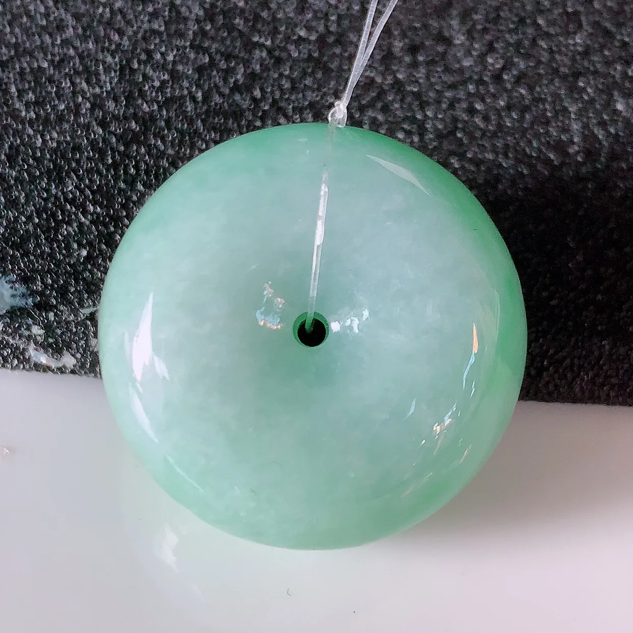 自然光实拍，冰润飘绿翡翠平安扣吊坠，形体饱满圆润，平安扣肥嘟嘟的，平平安安，种水很好，配戴精美！#49.10