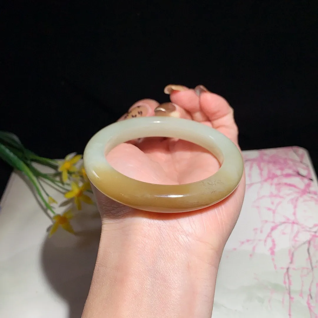 和田玉55.5圈且末糖手镯！玉质细腻油润 底色纯净  无纹裂 脂粉好，品质高。