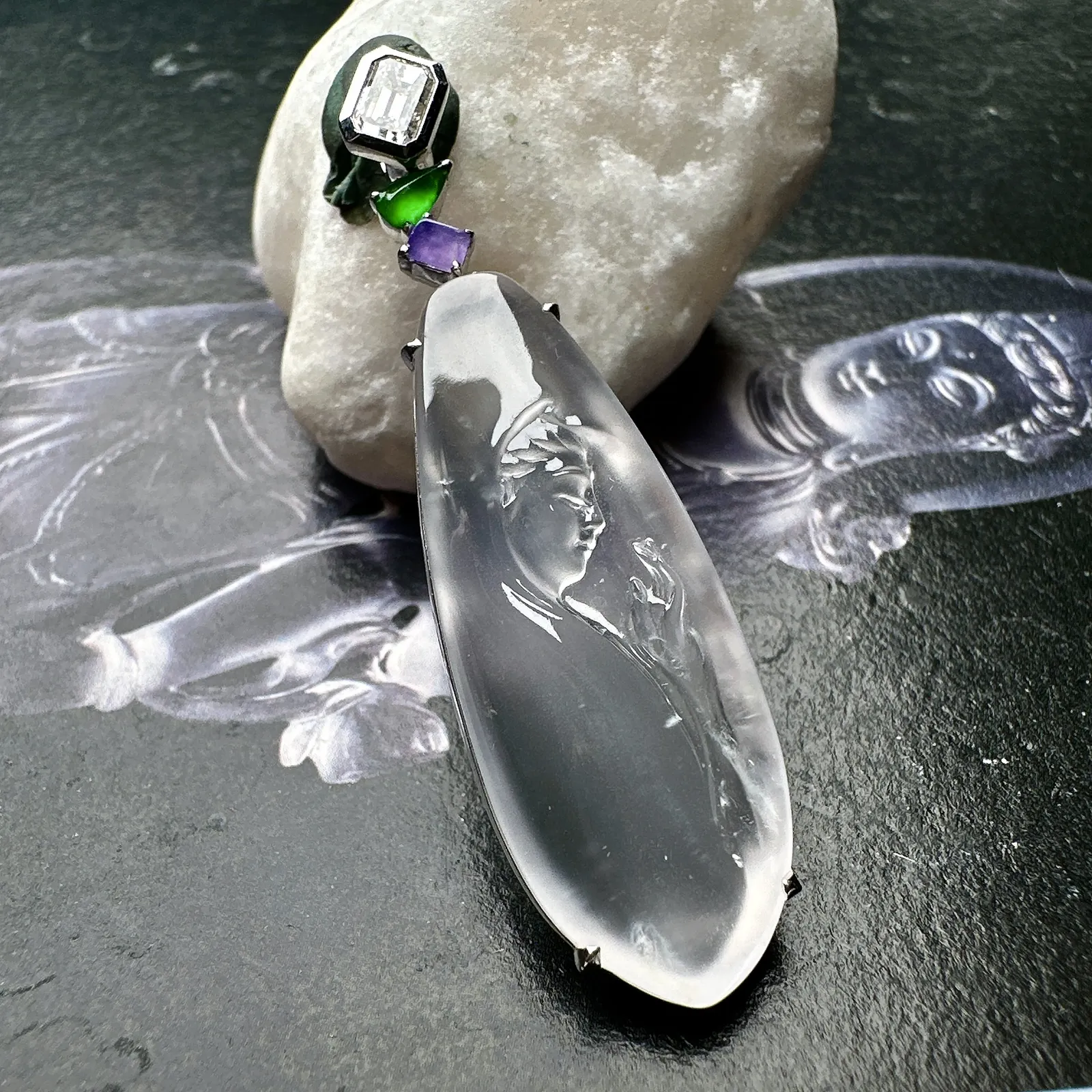 【玻璃种观音首吊坠】侧面像，料子通透闪亮，质地致密，种老起强胶感，玻璃光泽强烈。人物面部开脸生动，雕