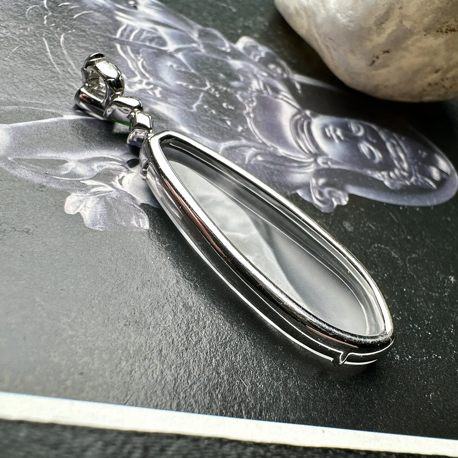 【玻璃种观音首吊坠】侧面像，料子通透闪亮，质地致密，种老起强胶感，玻璃光泽强烈。人物面部开脸生动，雕刻很精细，表情端庄祥和。料子纯净，18K金钻镶嵌，裸石尺寸33.3*13*2.8毫米